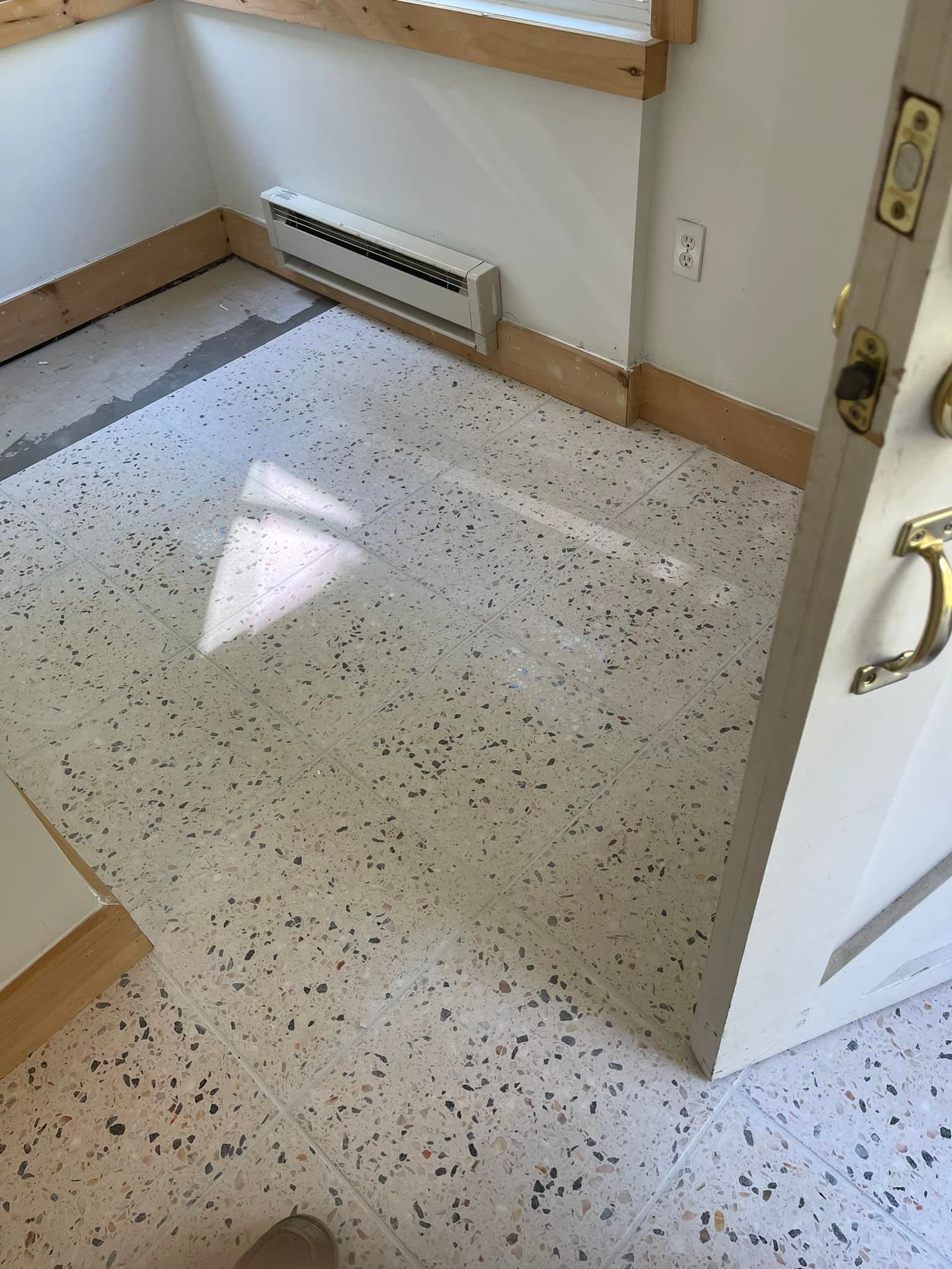A room with a white tile floor and a door.