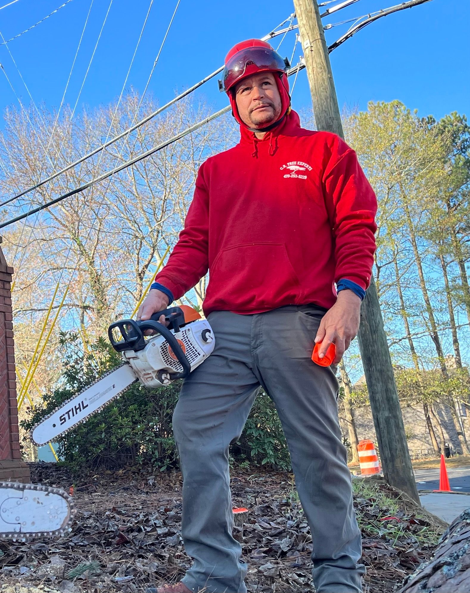 Orange chainsaw holding by a tree service crew