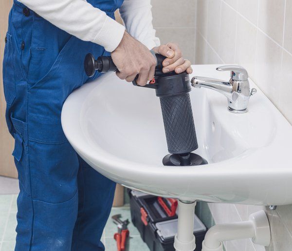 Plumber Fixing Clogged Drain — Streamwood, IL — United States Drain & Sewer Plumbing Plumber Fixing Clogged Drain — Streamwood, IL — United States Drain & Sewer Plumbing