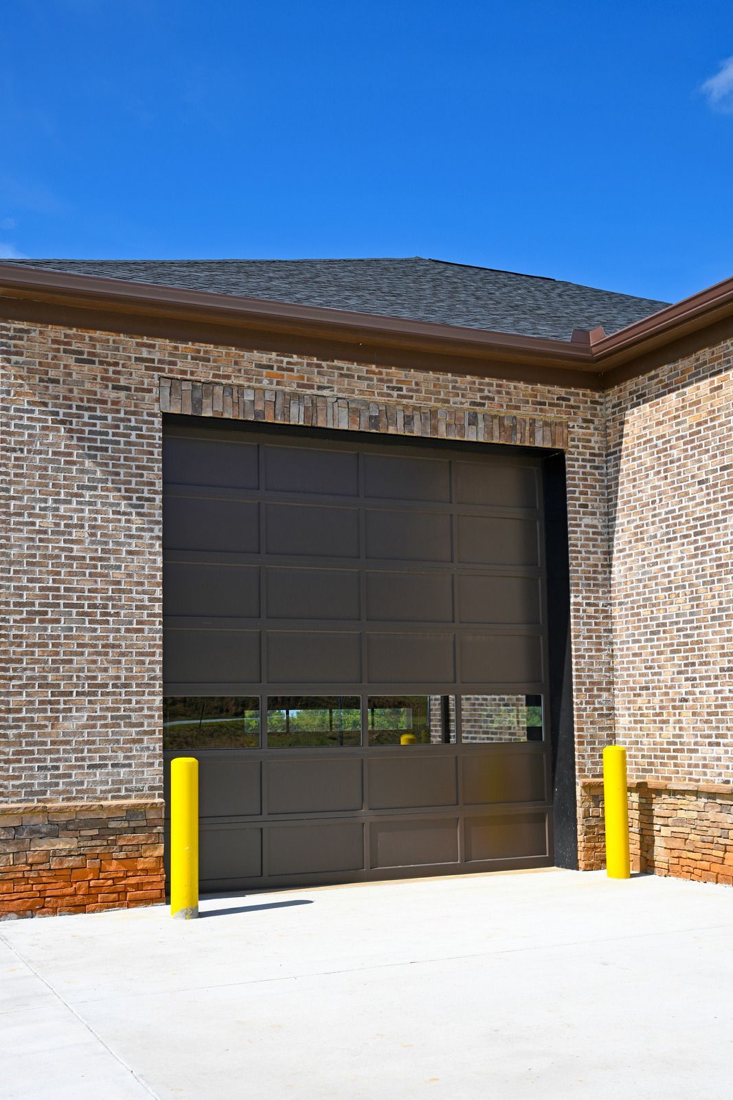 A large garage door is sitting on the side of a brick building.
