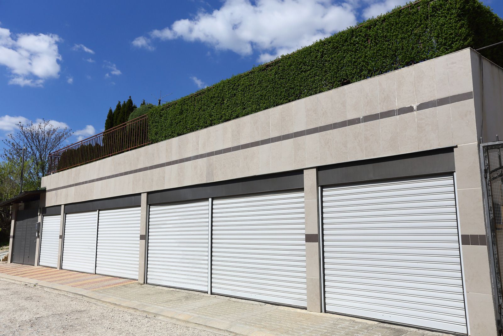 A row of white garage doors with a pattern on them