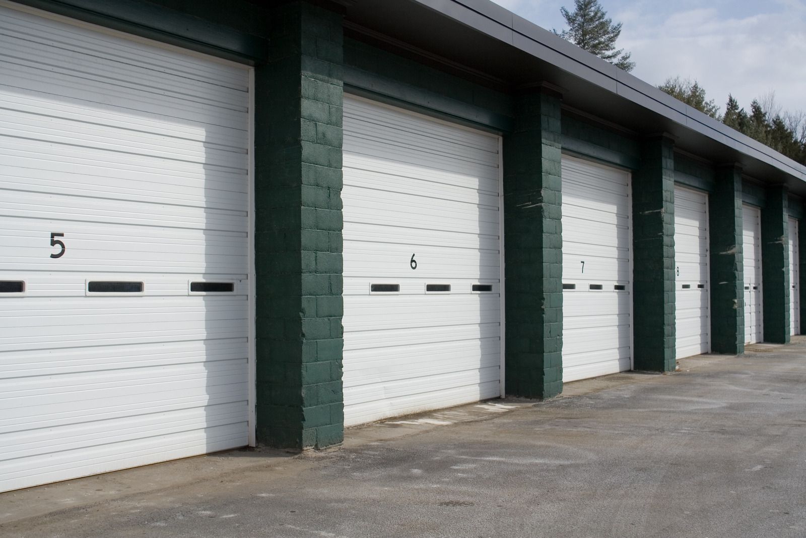 A row of white garage doors with the number 5 on them