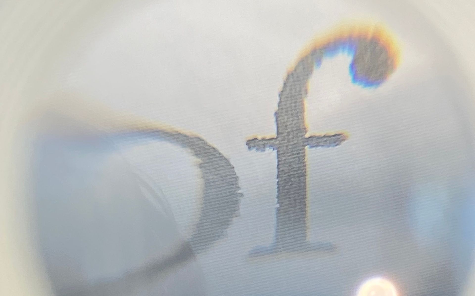 Abstracte afbeelding van het logo, licht vervaagd doordat dit door een loep wordt bekeken.