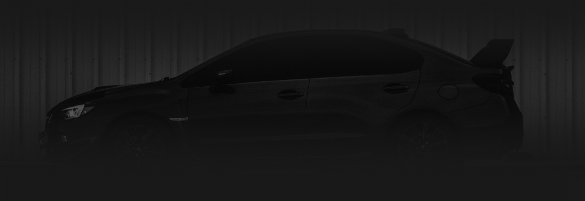 Silhouette of a black car against a dark background; a spoiler is visible. | Royal Automotive Repair