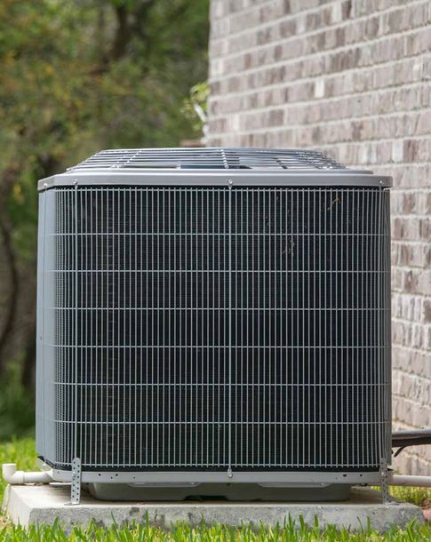 HVAC Air Conditioning Unit on concrete slap with new construction brick house