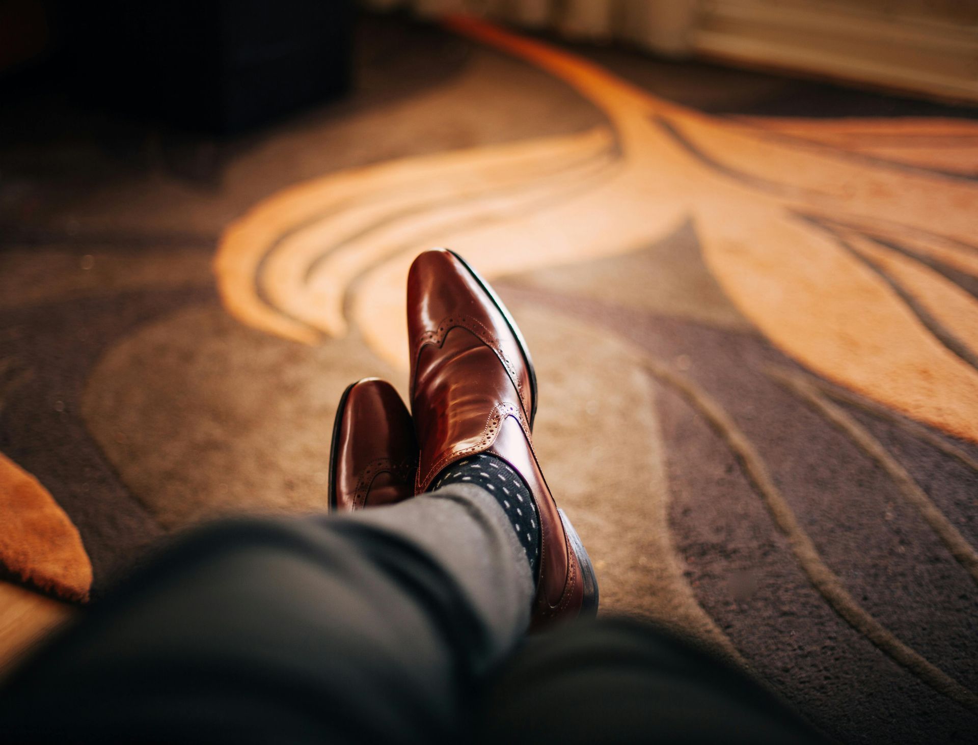 A person is laying on the floor with their feet up and wearing brown shoes.