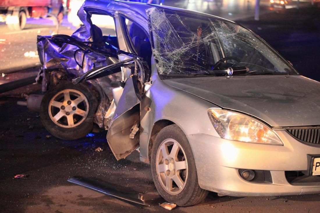 A car with a broken windshield is parked on the side of the road.