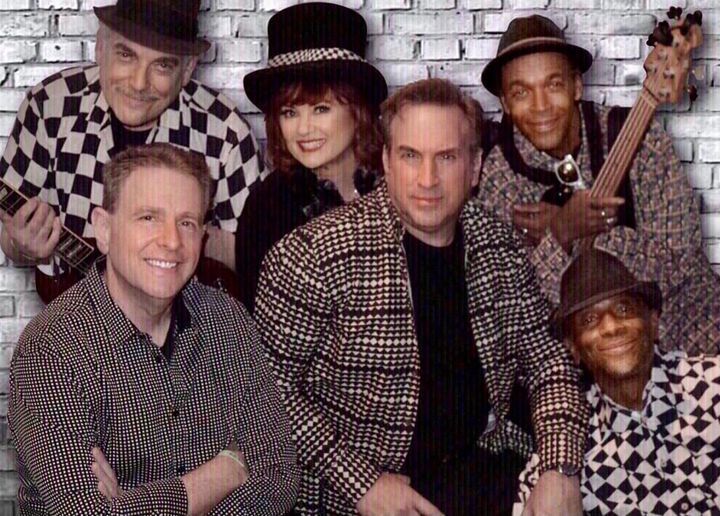 A group of people posing for a picture in front of a brick wall