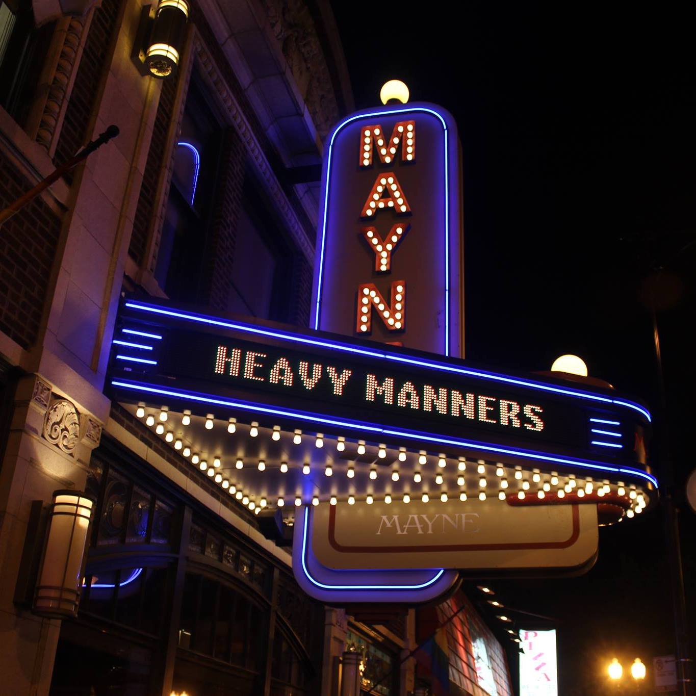 A heavy manners sign is lit up at night