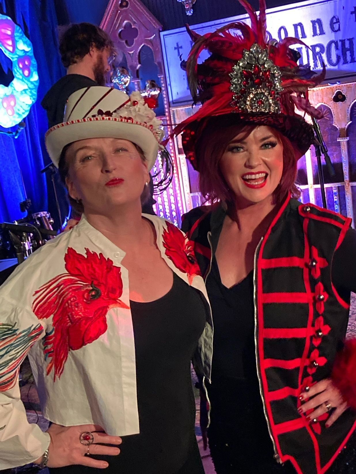 Two women are posing for a picture in front of a sign that says bonne torch