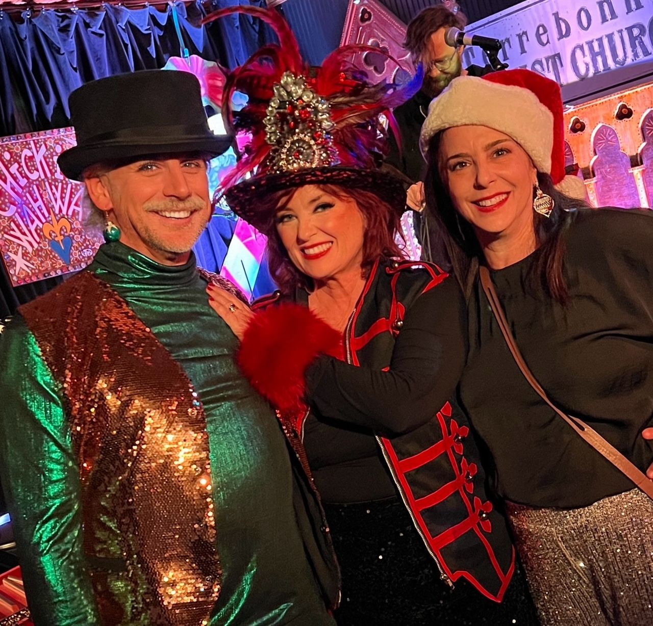 Three people posing for a picture in front of a sign that says reborn st church