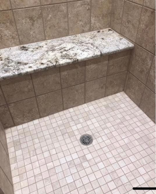 In this picture you can see we replaced the tile on the shower bench top with a solid piece of granite sloped for water to fall of the top. Shower floor tile was replaced as well.  