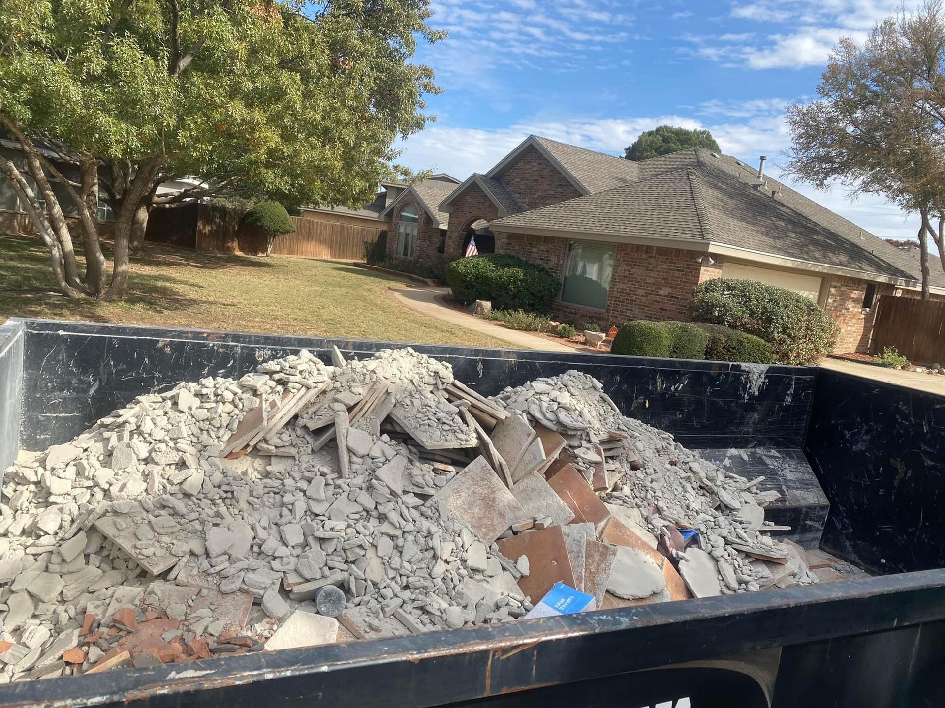 Roll Off Dumpster with tile and thinset removed from a home. 