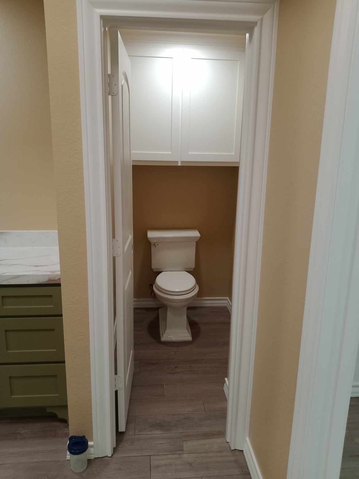 Updated color scheme in bathroom toilet room and added a upper cabinet with shaker style door 