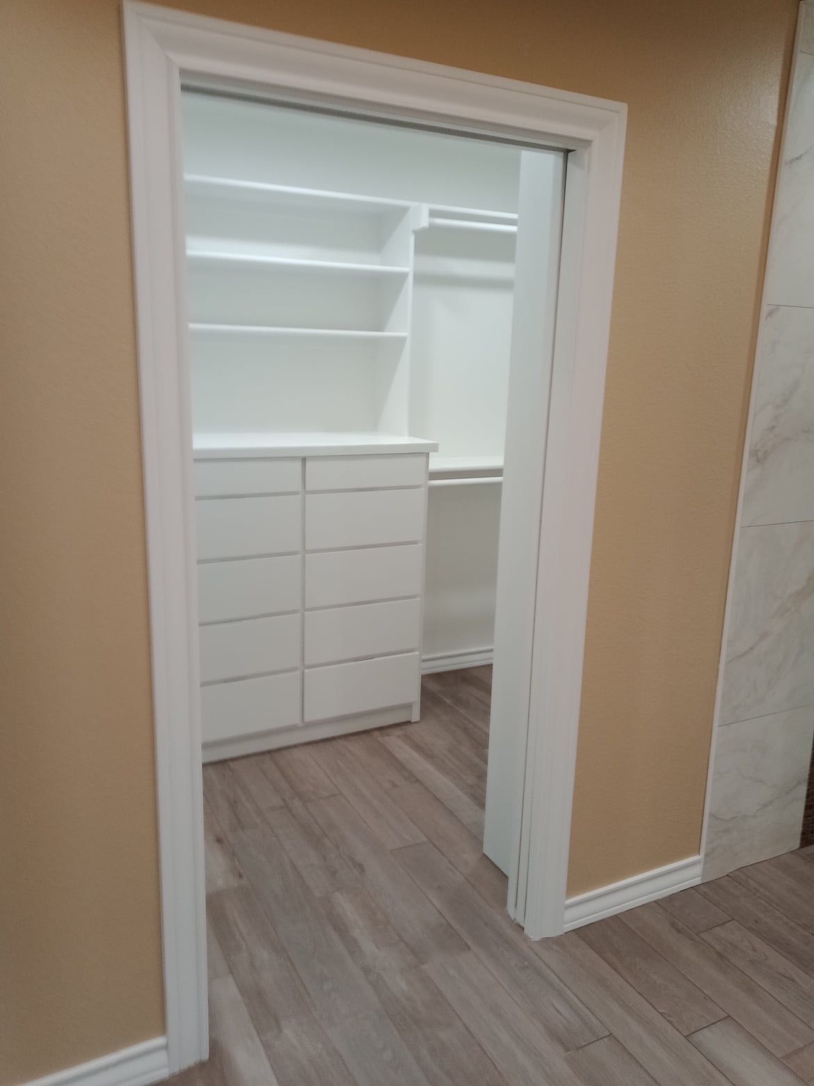 Added one pocket door to closet and added new cabinetry for more efficient use of space. 