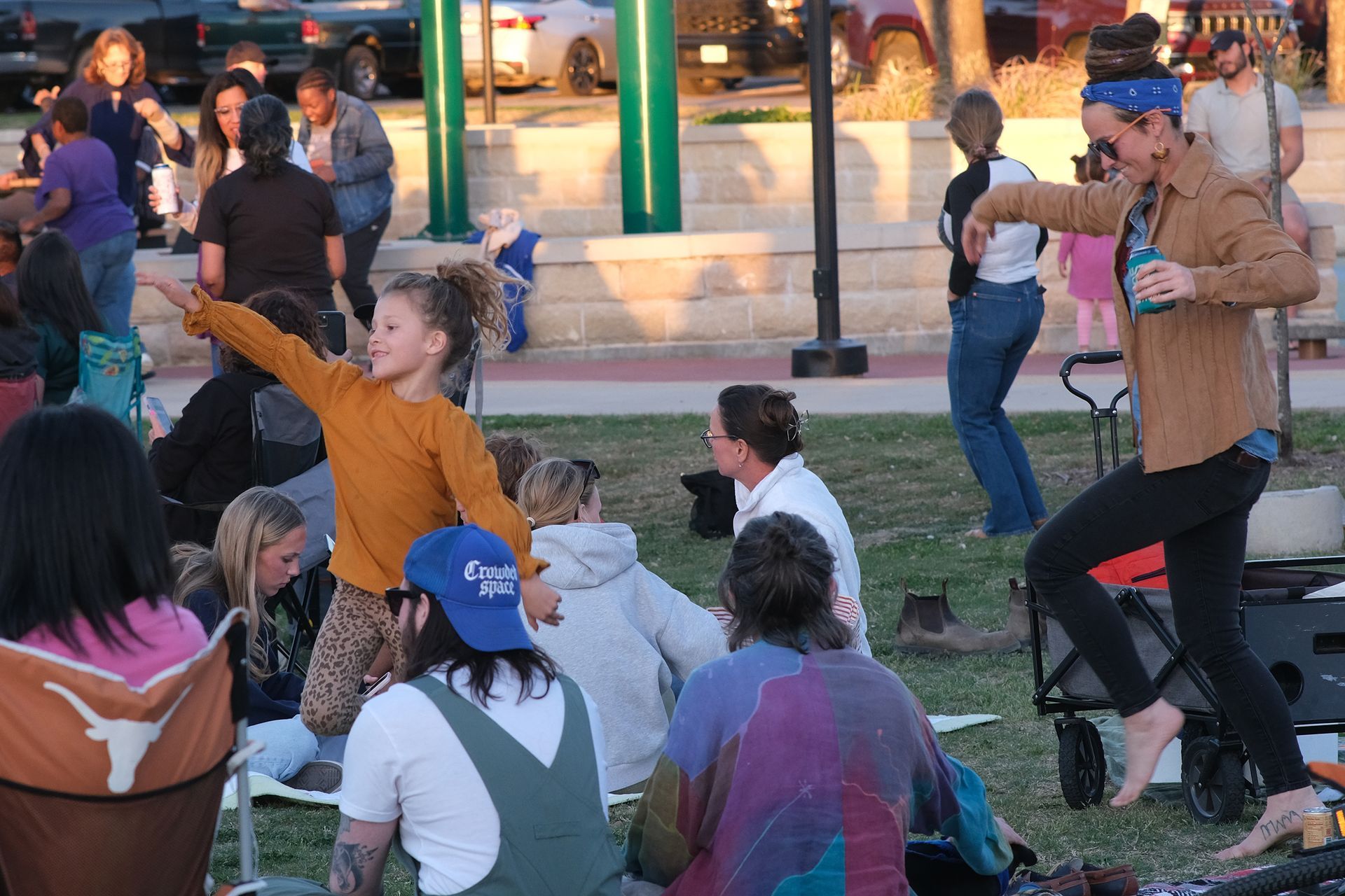 People dancing and relaxing at an outdoor event in a park.