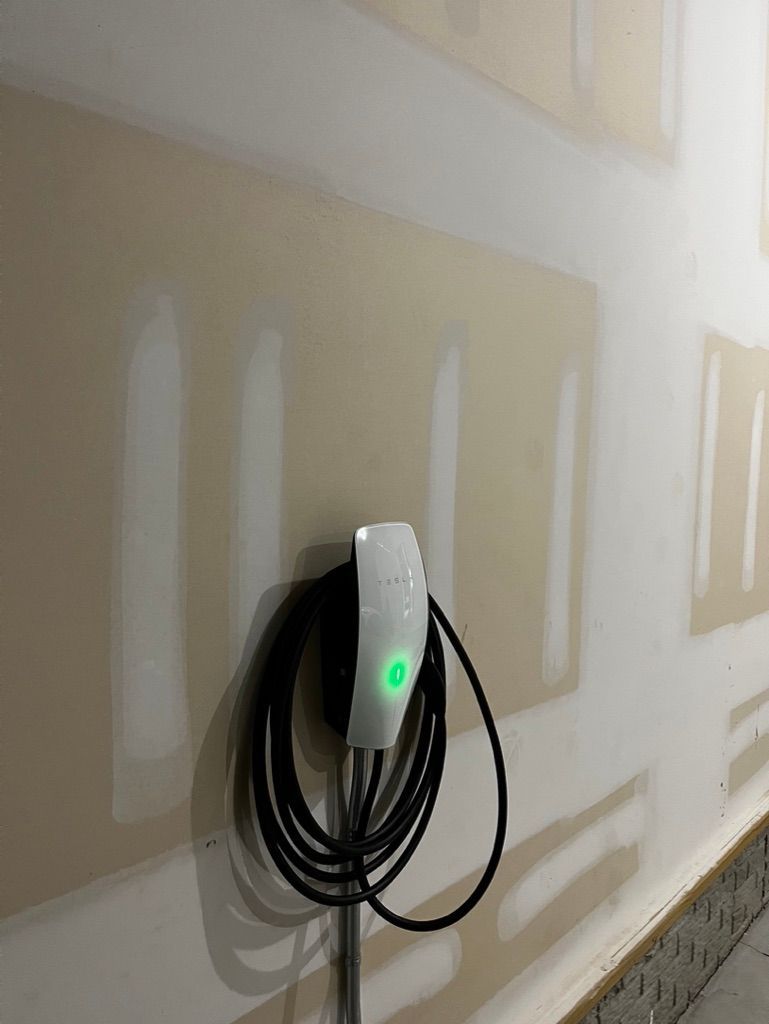 A charger is attached to a wall in a garage.