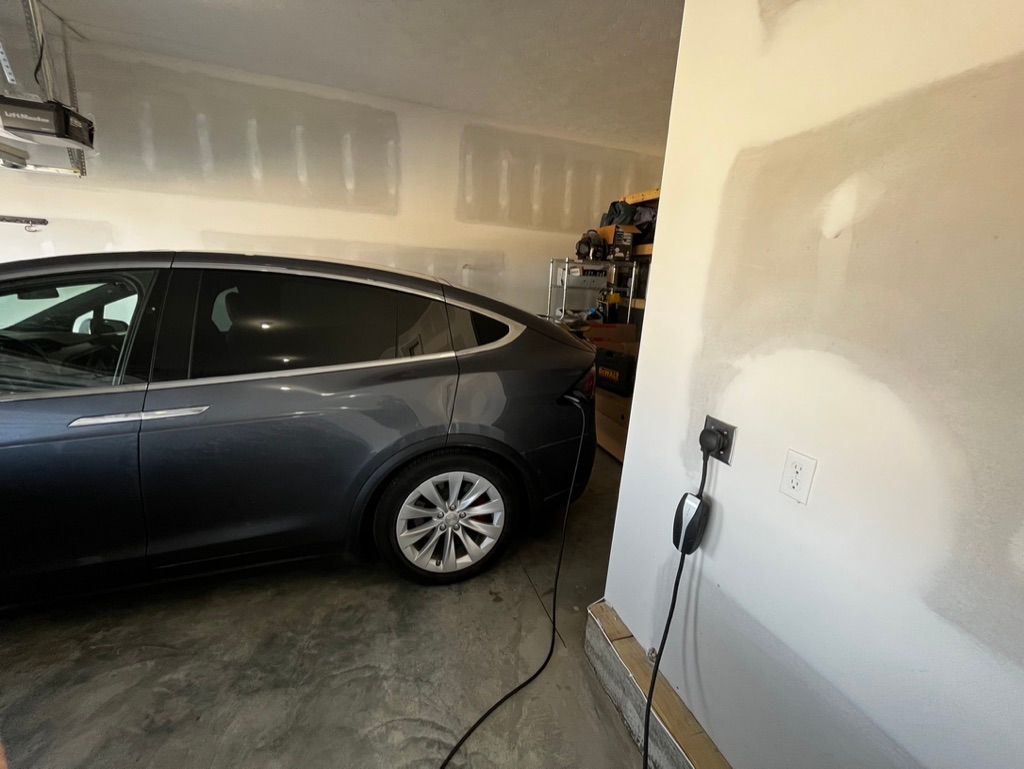 A tesla model s is charging in a garage.