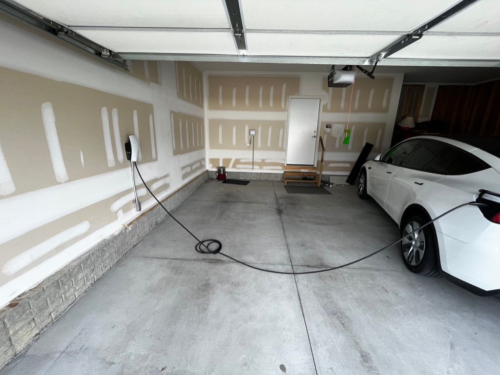 A white car is being charged in a garage