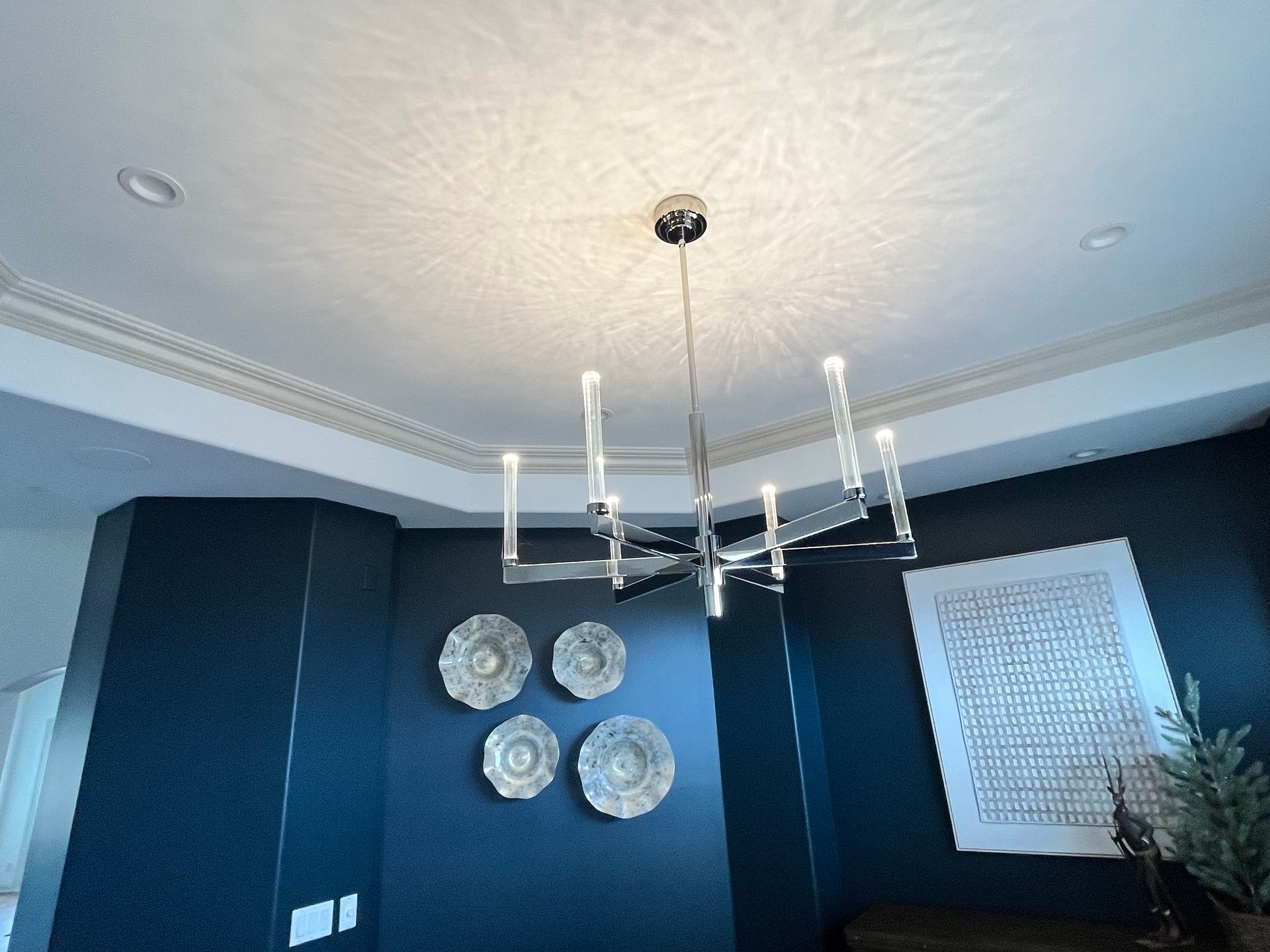 A dining room with a chandelier hanging from the ceiling