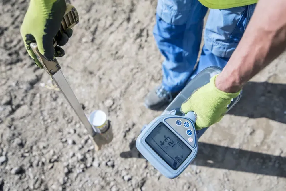 A Person in Work Gloves Uses a Handheld Electronic Soil — CH Electrics in Emerald, QLD