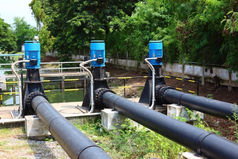 Three Blue Electric Pump Motors Connected to Black Pipes — CH Electrics in Emerald, QLD