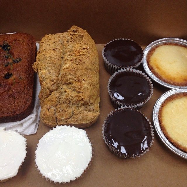 A box filled with a variety of pastries and cupcakes