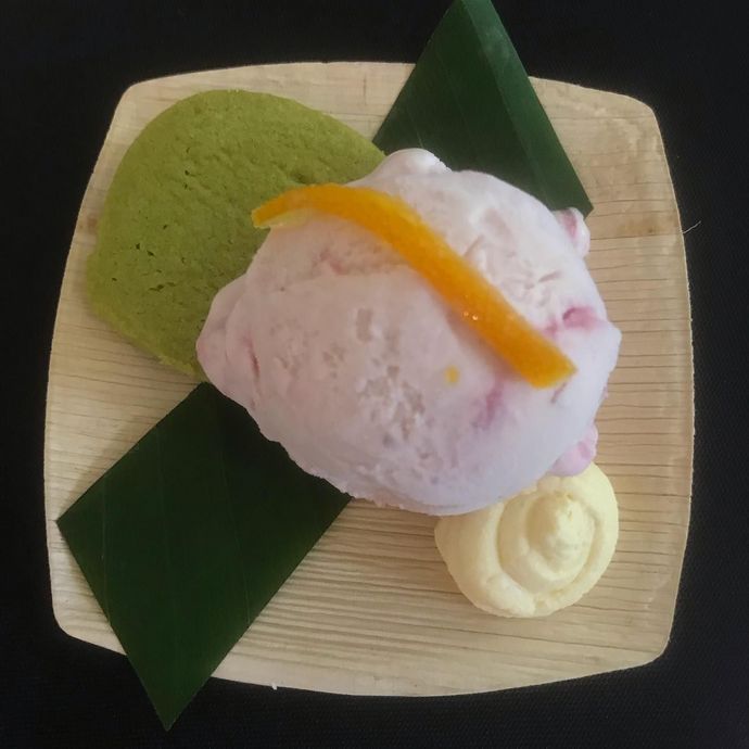 A scoop of ice cream on a wooden plate