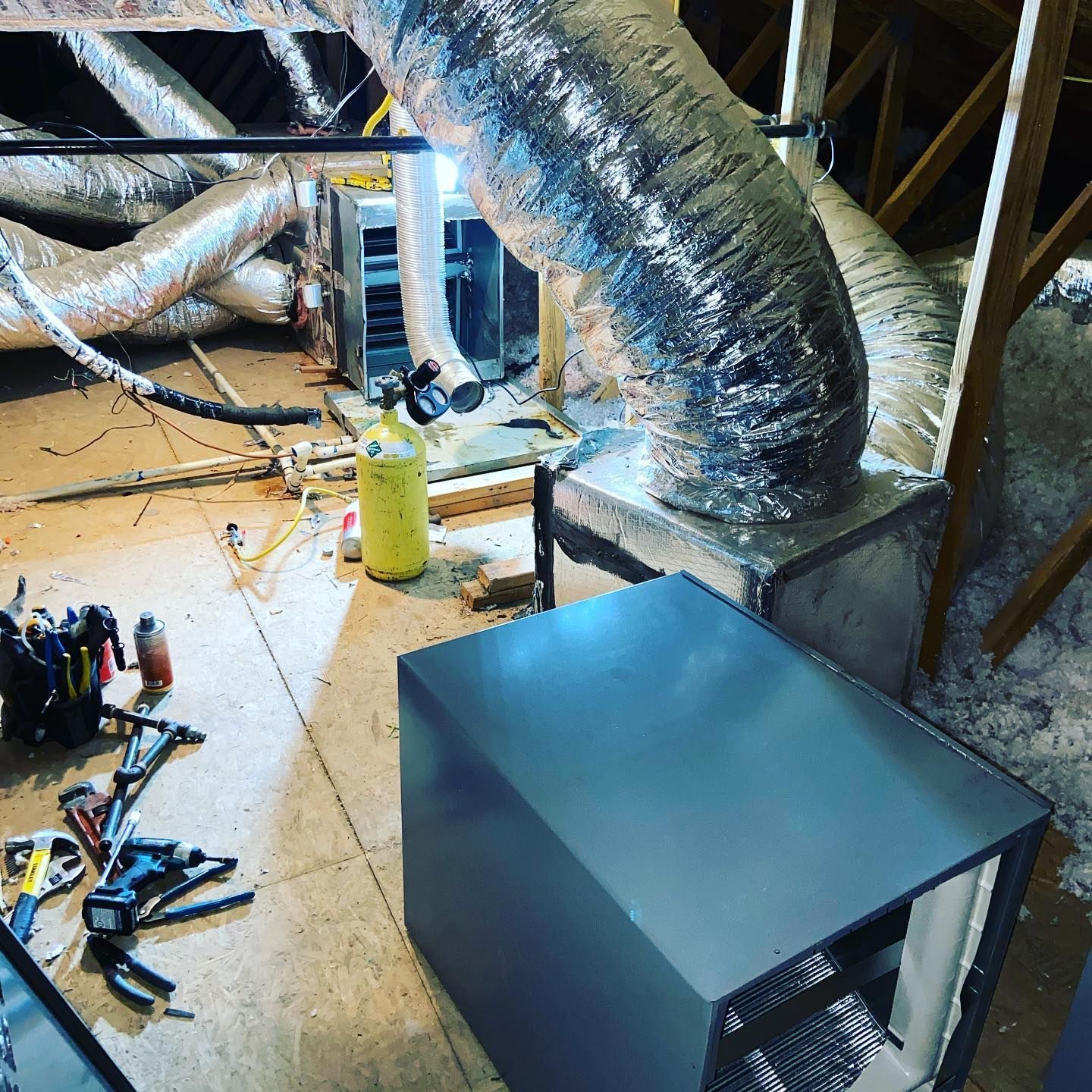 A room with a lot of ducts and tools on the floor.