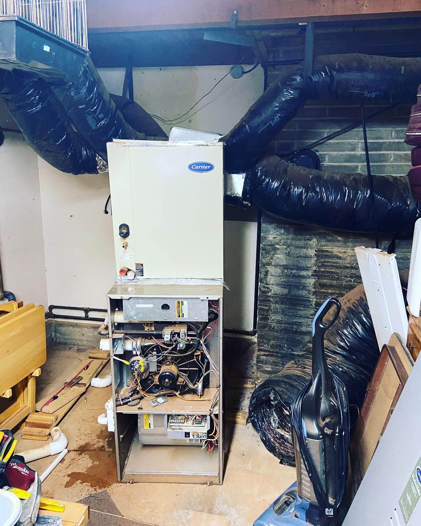 A broken air conditioner is sitting in a messy room.