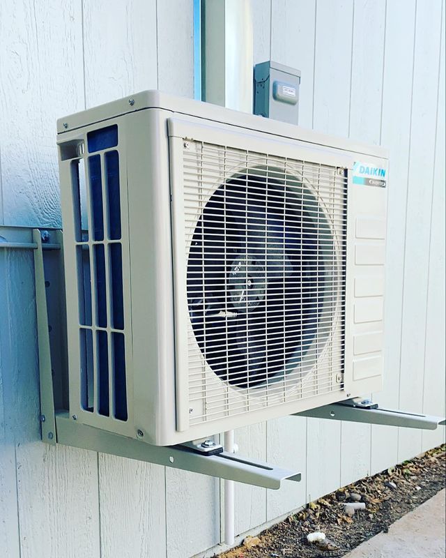 An air conditioner is mounted on the side of a building