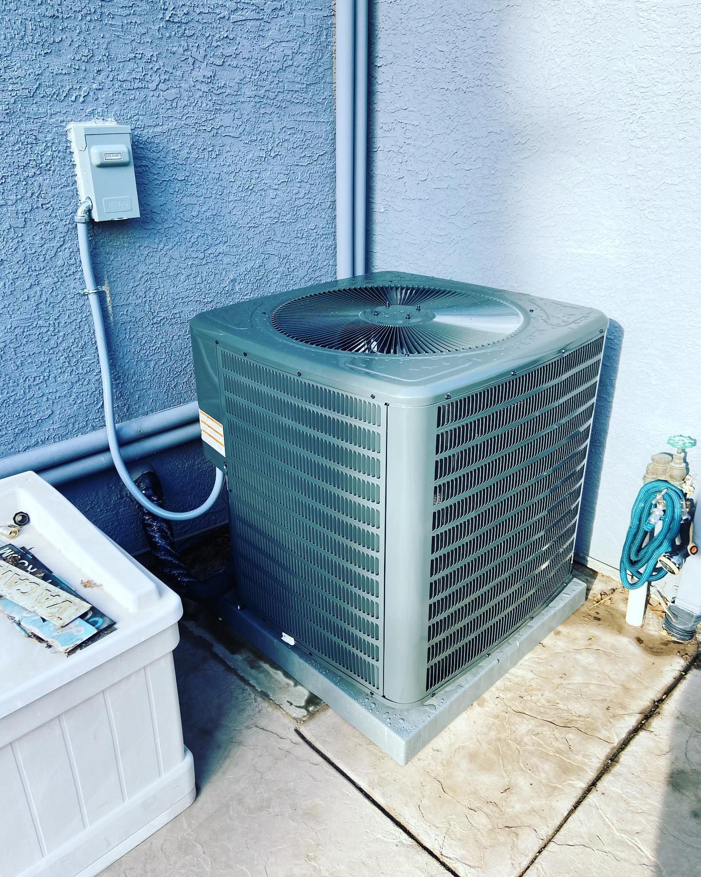A large air conditioner is sitting on the side of a building.