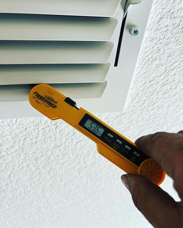 A hand is holding a digital thermometer that reads 5.01