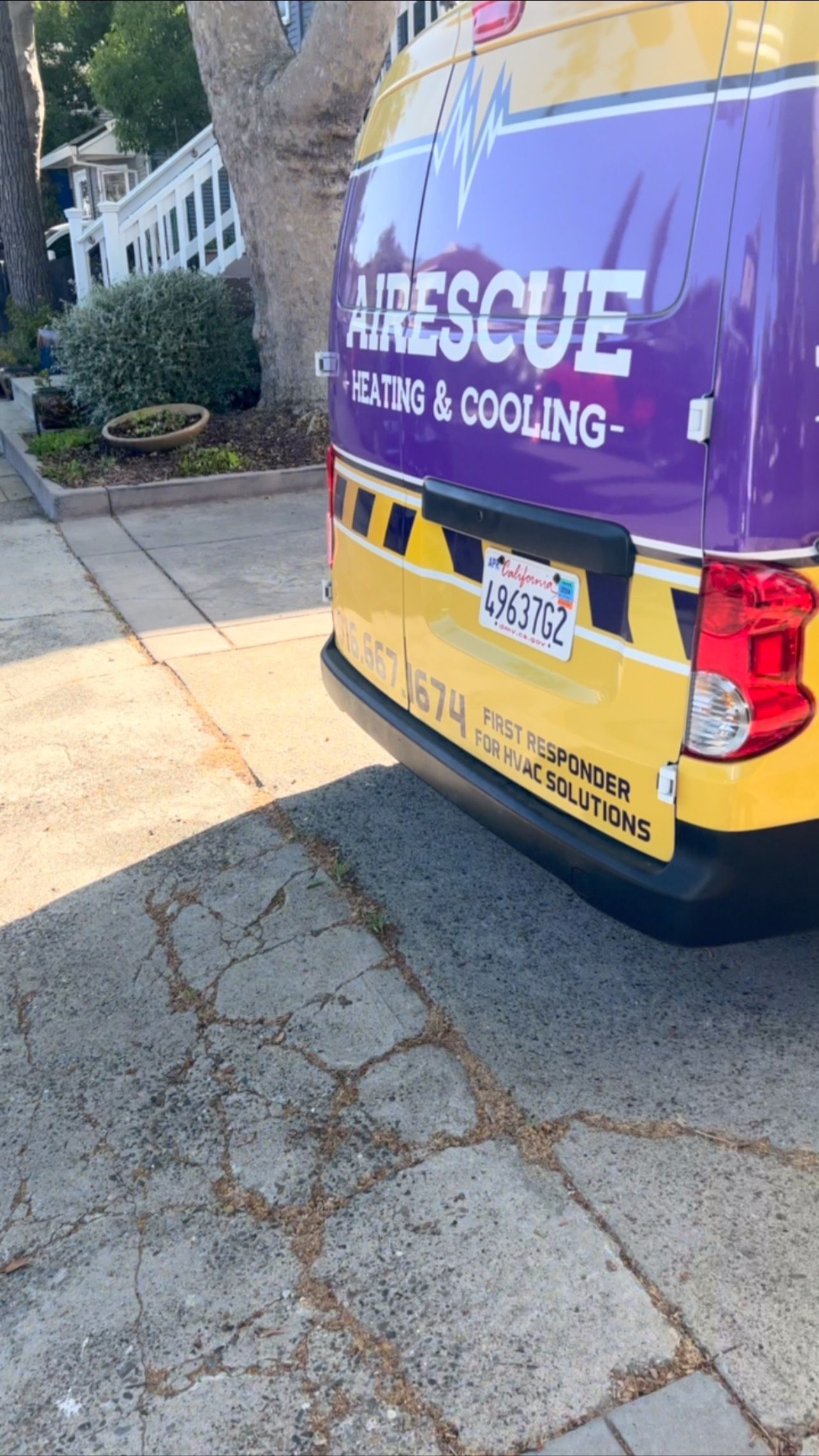 A purple and yellow van is parked on the side of the road.