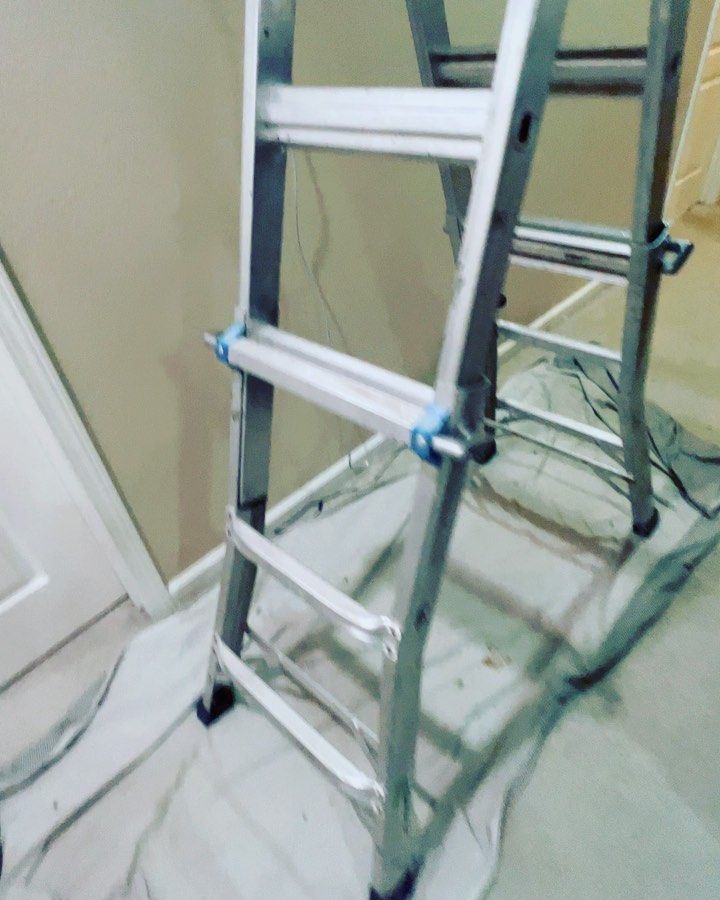 A ladder is sitting on a white cloth in a room.