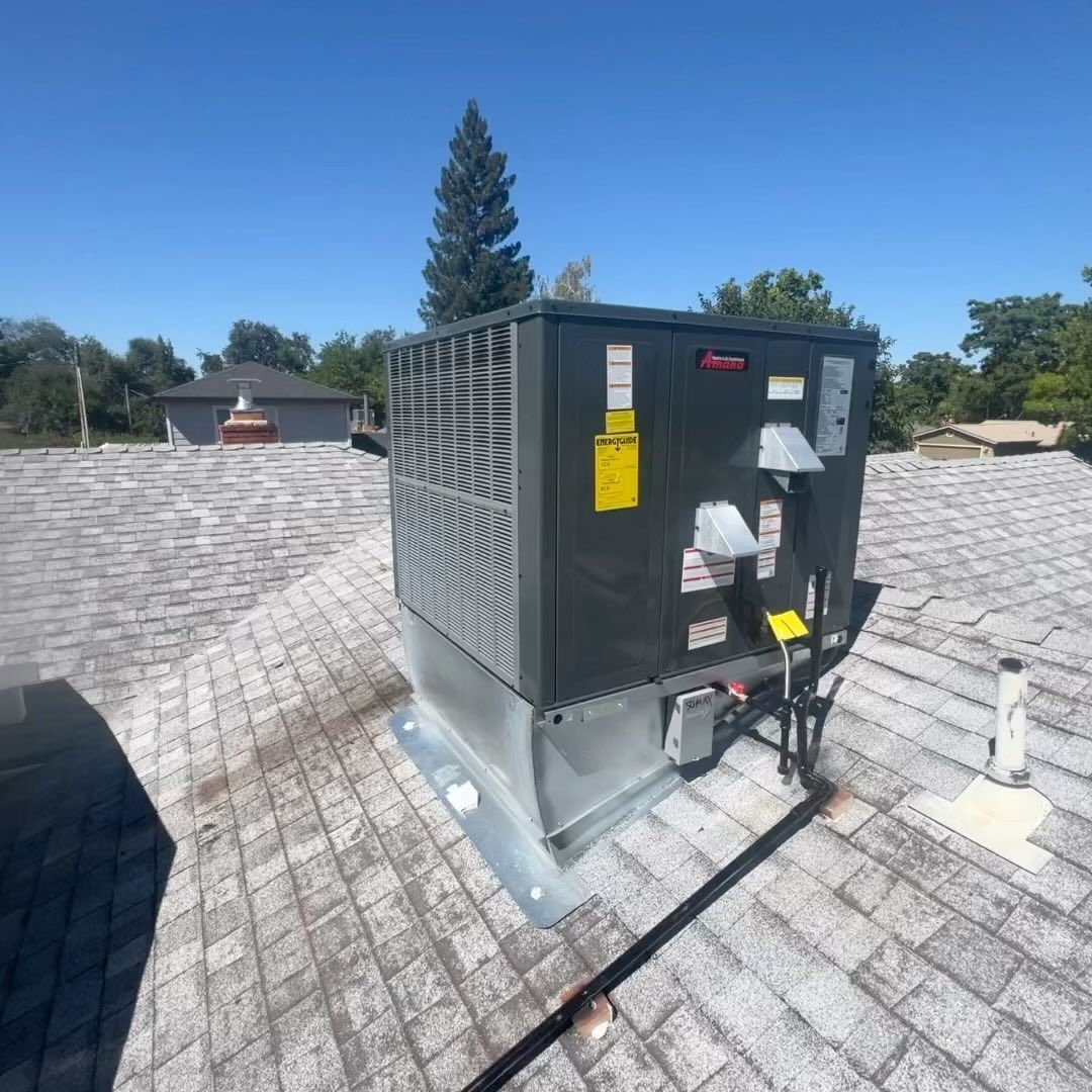 A large air conditioner is sitting on top of a roof.