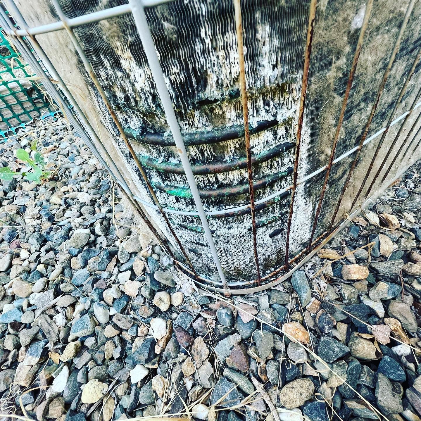 A metal fence is sitting on top of a pile of rocks.