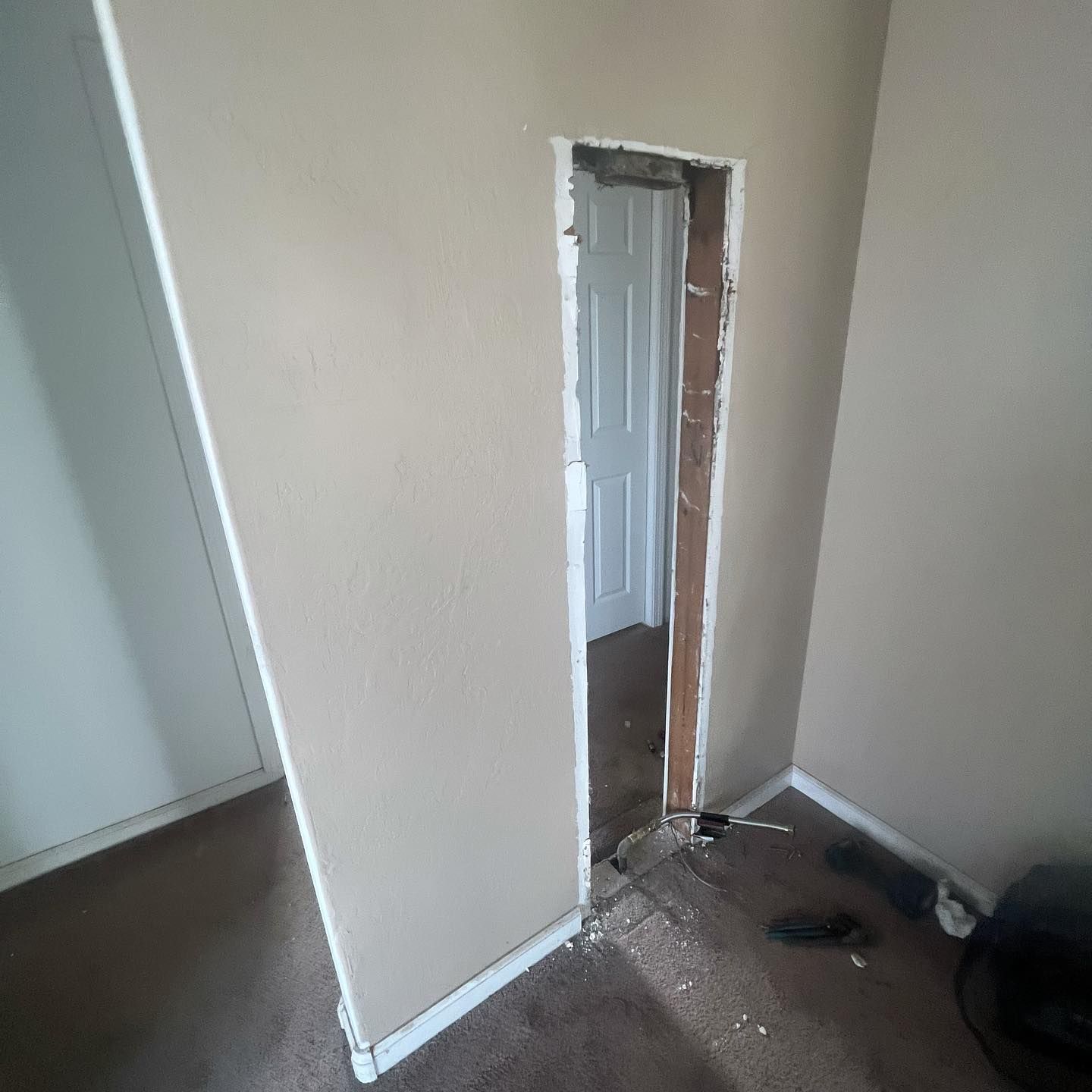 A door is missing in a room with a hole in the wall.