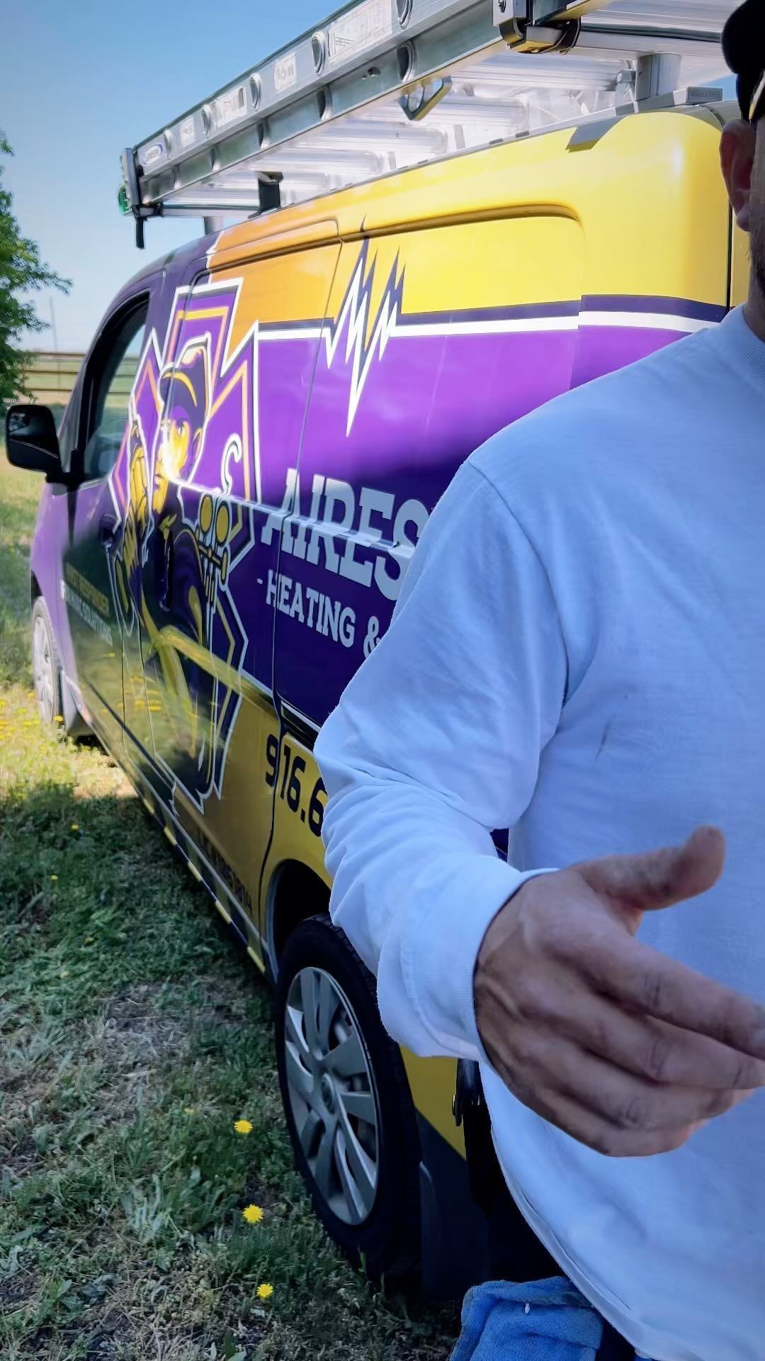A man is standing in front of a purple and yellow van.