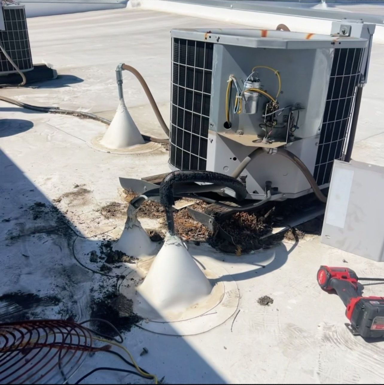 A broken air conditioner is sitting on a roof
