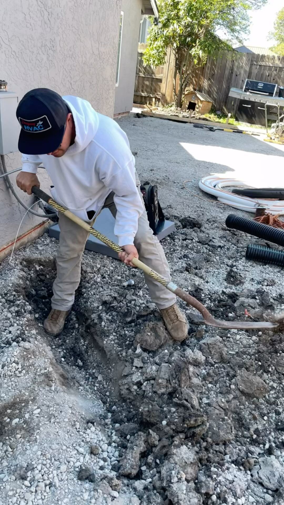 A man is digging in the dirt with a shovel.