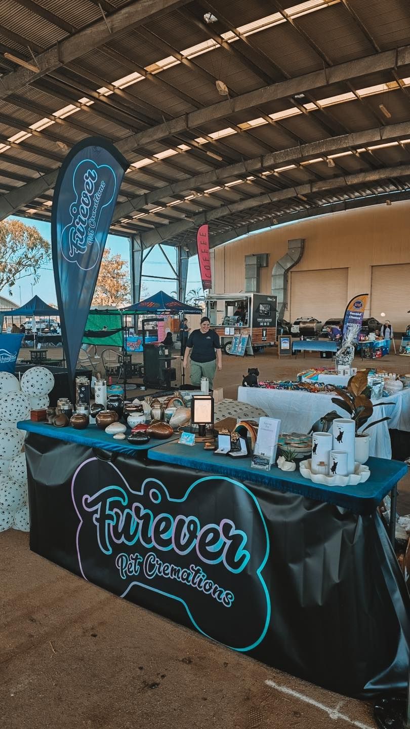 Dog Treat Vendor Booth at an Outdoor Market With a Sign — Furever Pet Cremations in Rockhampton, QLD