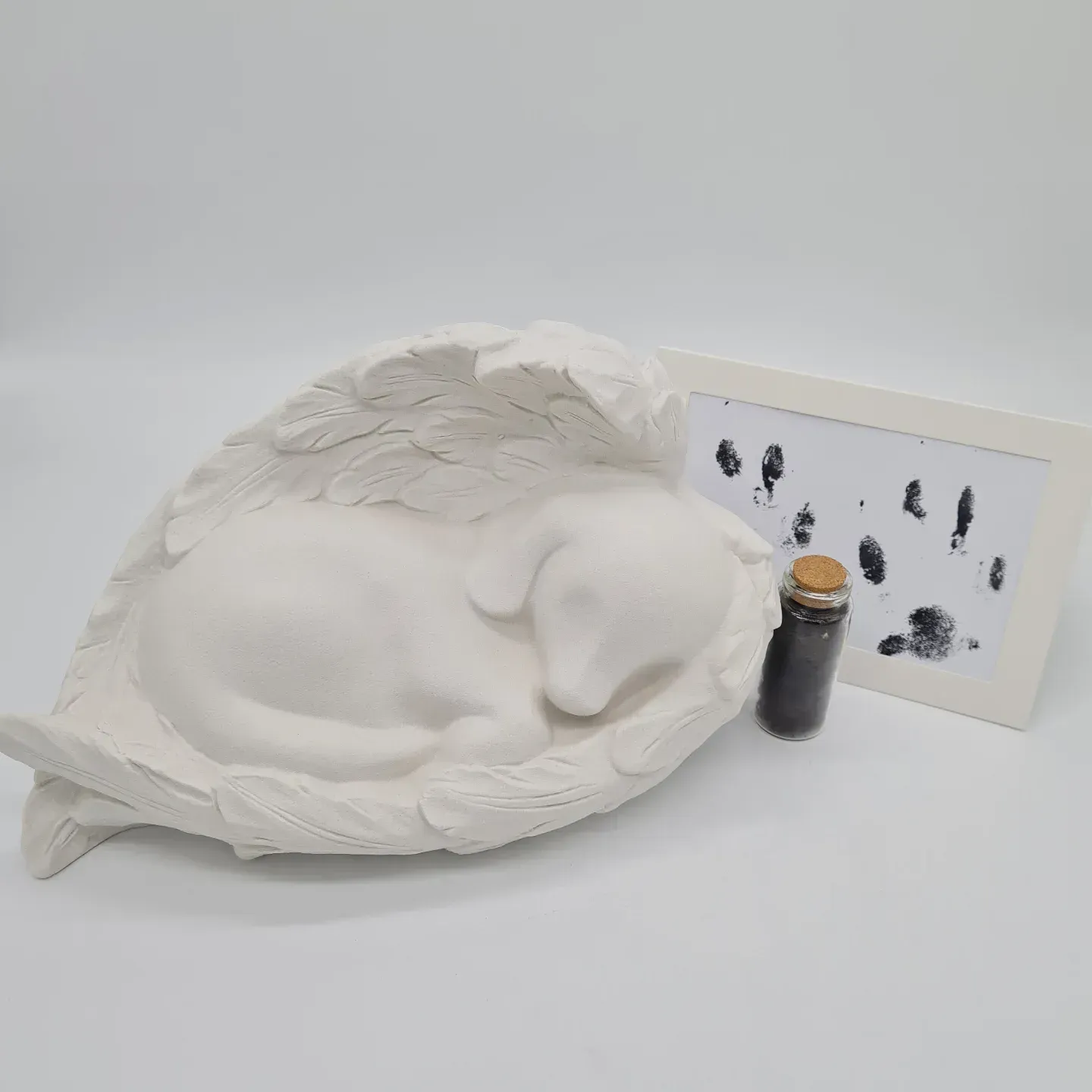 White Dog Urn in Angel Wings With Paw Print Frame and Small Vial — Furever Pet Cremations in Yeppoon, QLD