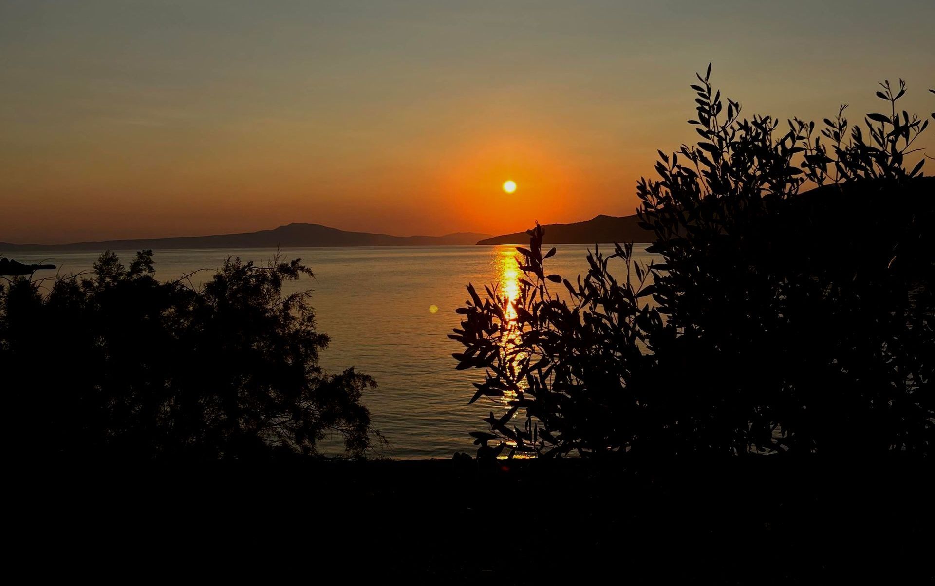 Solnedgang over et fjell i det fjerne.