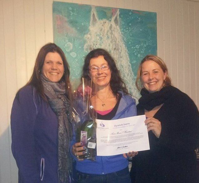 Tre kvinner stiller opp på bilde med en med sertifikat