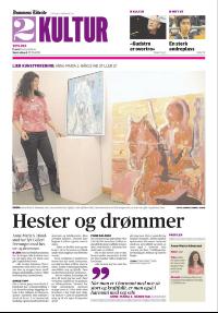 En kvinne står ved siden av et maleri på en avis.