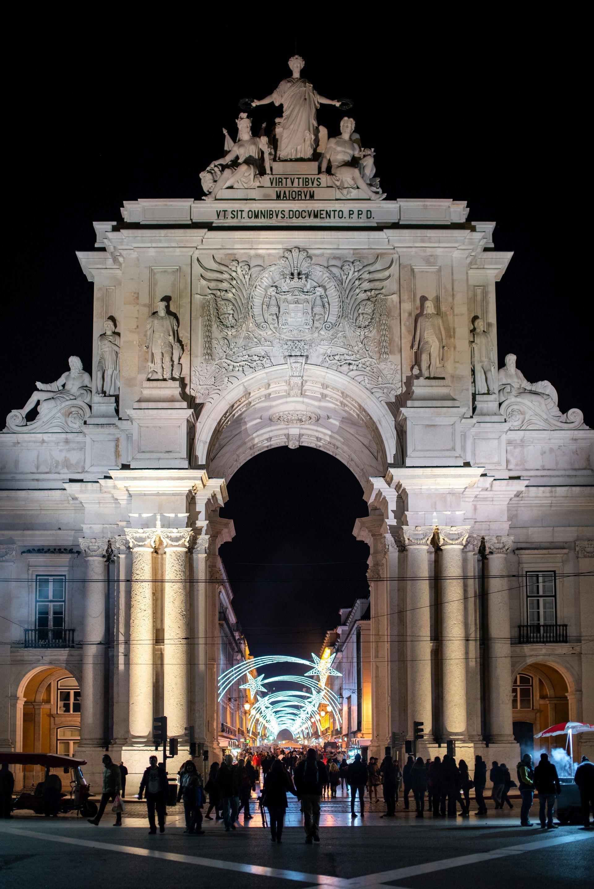 Pastel de nata, bolo rei e copos de Ginjinha sob as luzes de Natal do Baixa de Lisboa em dezembro