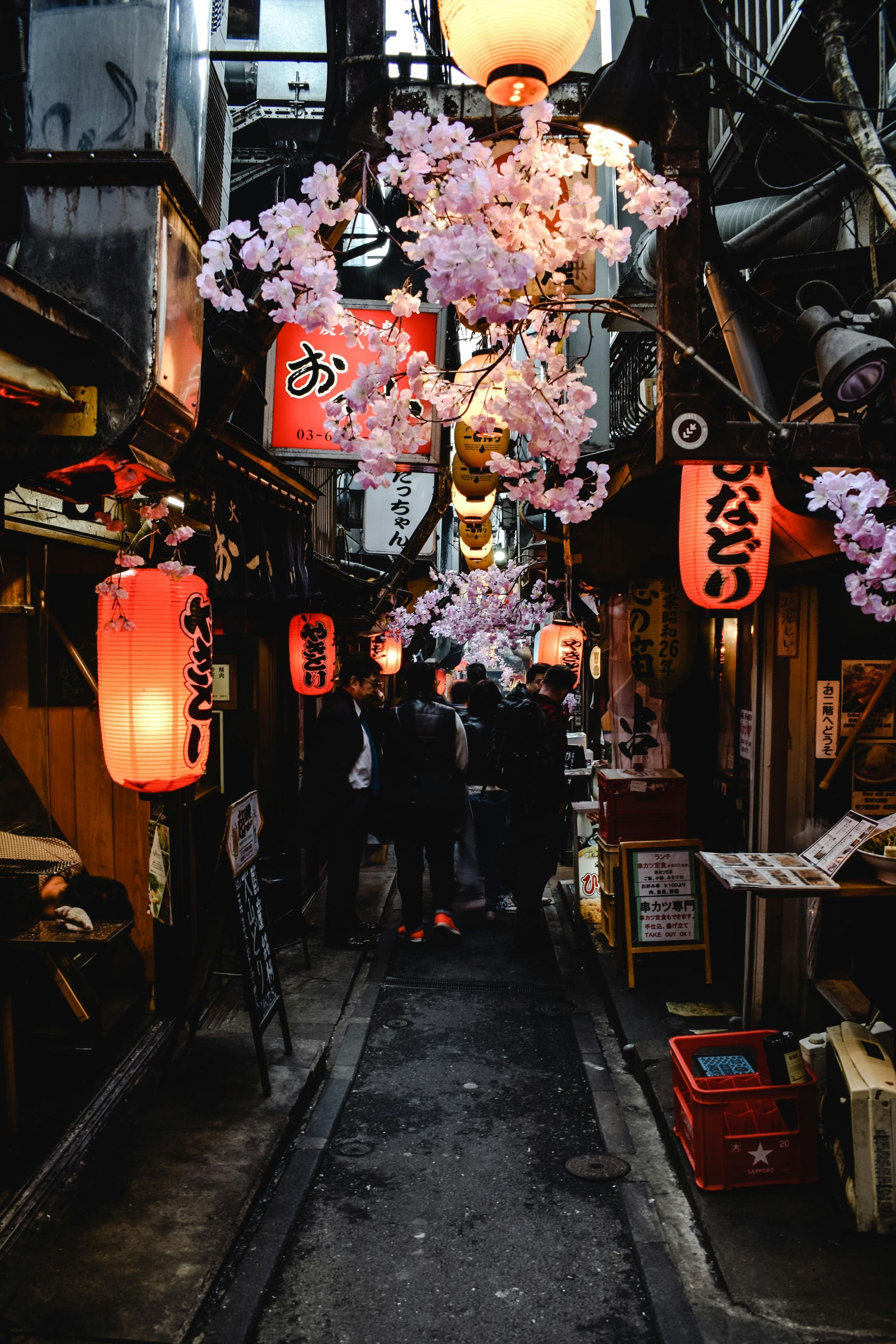 Tourists walking through lantern-lit food stalls in Ueno, Tokyo