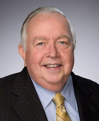 A man in a suit and tie is smiling for the camera.