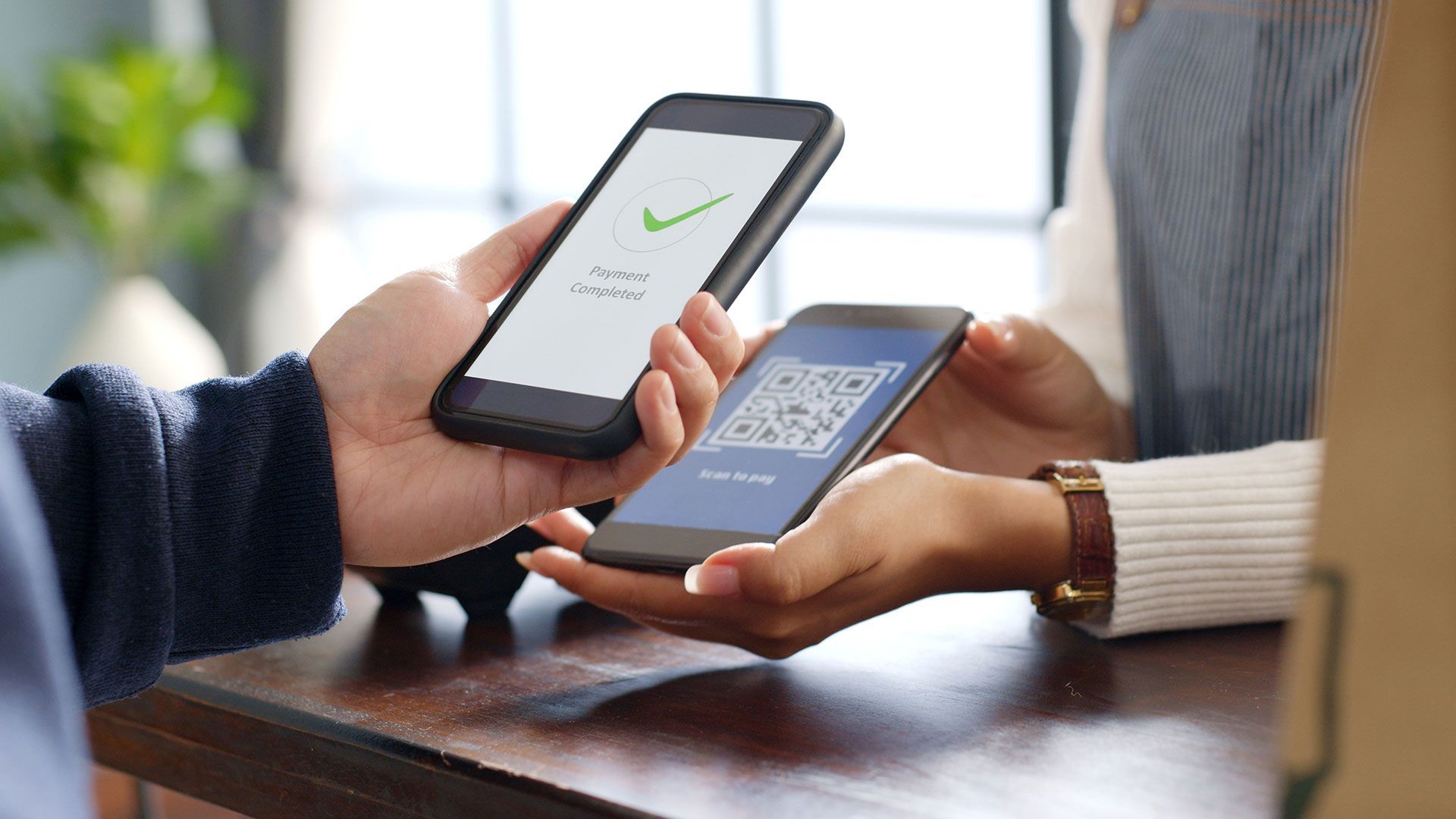 A man and a woman are holding cell phones in their hands.